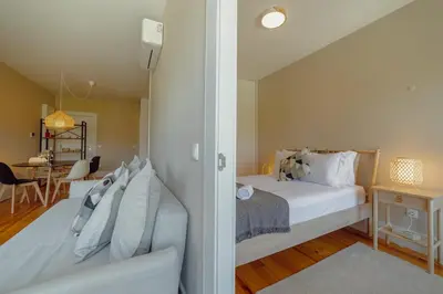 a bedroom with a white bed and a dining room at Boavista Premium Apartments by Vacationy in Porto