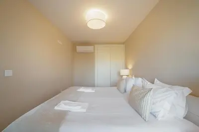 a bedroom with a bed with white sheets and pillows at Boavista Premium Apartments by Vacationy in Porto