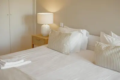 a white bed with pillows and a lamp on a table at Boavista Premium Apartments by Vacationy in Porto