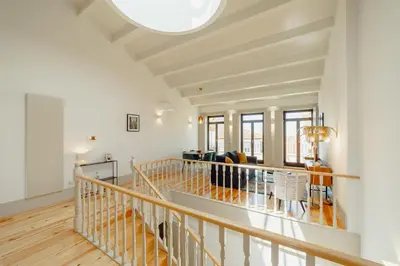a large white room with a wooden floor and a ceiling at Legacy Oporto Premium Apartments by Vacationy in Porto