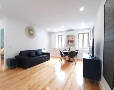 a living room with a black couch and a table at Davis Home, Refúgio de Charme no Porto in Porto