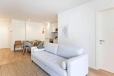 a living room with a white couch and a table at Paraíso -1B w/ AC & Patio by LovelyStay in Porto