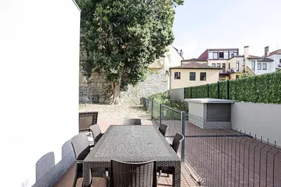 a patio with a table and chairs on a balcony at Paraíso -1B w/ AC & Patio by LovelyStay in Porto