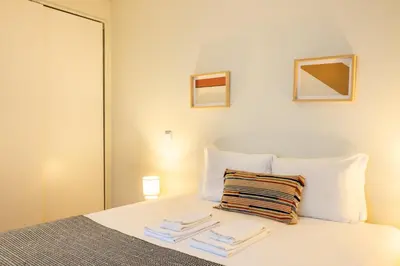 a bedroom with a bed with towels on it at Casa do Ofício Galerista in Porto