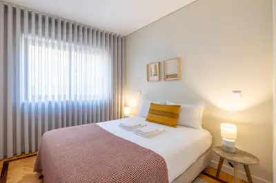 a bedroom with a large bed and a window at Casa do Ofício Galerista in Porto