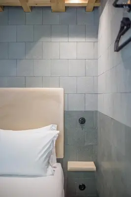 a bed with a white pillow and a shower at 62 Design House II in Porto