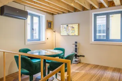 a dining room with a glass table and green chairs at 62 Design House II in Porto