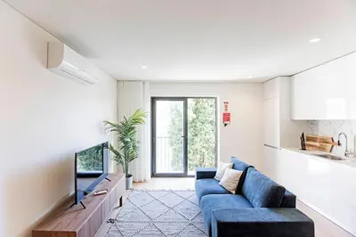 a living room with a blue couch and a tv at NEW Cozy and Modern Apartment in the heart of Porto in Porto