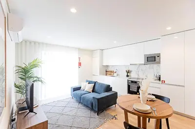 a living room with a blue couch and a table at NEW Cozy and Modern Apartment in the heart of Porto in Porto
