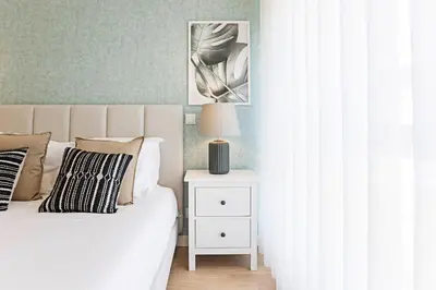 a bedroom with a bed and a night stand with a lamp at NEW Cozy and Modern Apartment in the heart of Porto in Porto