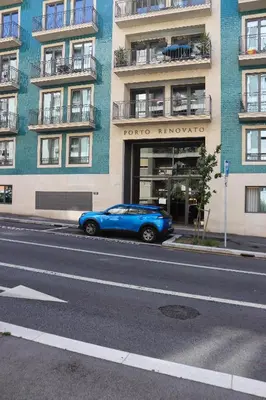 a blue car parked in front of a building at HM - Casa Ghiselini Porto 213 in Porto