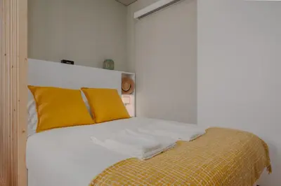 a bedroom with a bed with yellow pillows at Green Garden Luxury House w/ AC, Metro & Downtown in Porto