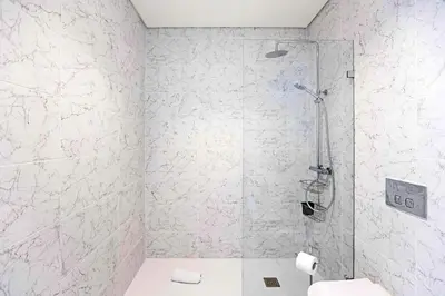 a bathroom with a shower with a toilet and a sink at Paraíso 1H w/ AC by LovelyStay in Porto