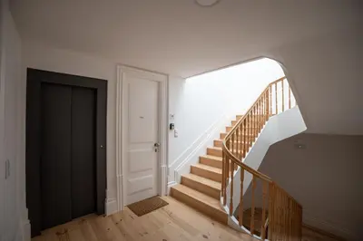 an empty hallway with stairs and a black door at Cedofeita Charming Flat in Porto