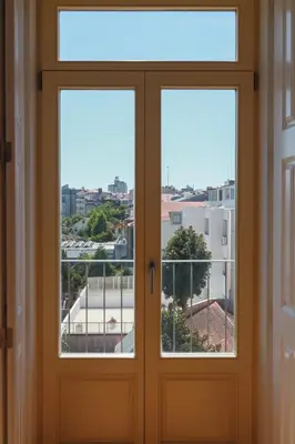 a door with a view of a city seen through it at Cedofeita Charming Flat in Porto