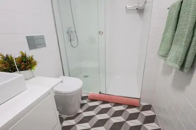 a bathroom with a toilet and a glass shower at Cedofeita Charming Flat in Porto