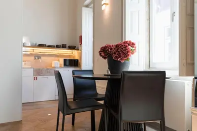 a kitchen with a table with chairs and a vase of flowers at Flores City Retreat in Porto