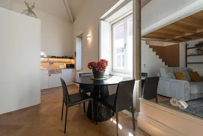 a dining room and living room with a table and chairs at Flores City Retreat in Porto