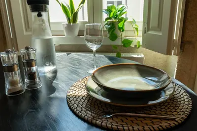 a table with a plate and a glass of wine at Flores City Retreat in Porto