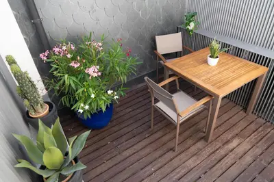 a balcony with a table and chairs and potted plants at Flores City Retreat in Porto
