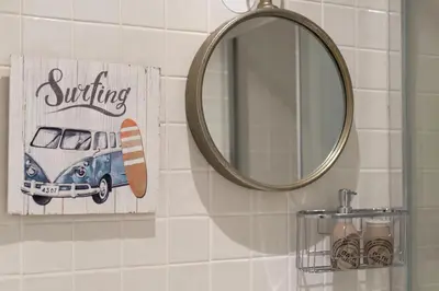 a bathroom with a mirror and a picture of a car at Santo António Oporto House in Porto