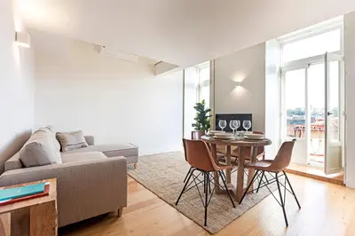 a living room with a table and a couch at Stunning Duplex Near River by LovelyStay in Porto