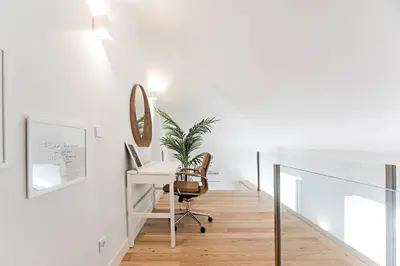 a white office with a desk and a mirror at Stunning Duplex Near River by LovelyStay in Porto