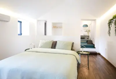 a white bedroom with a large bed with white sheets at Alegria Cool House in Porto