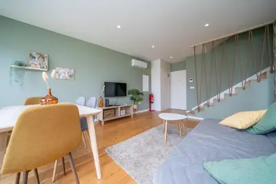 a living room with a bed and a table and a couch at Trindade Duplex by Amber Star Rent in Porto