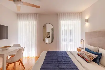 a bedroom with a bed and a table and a mirror at D&S -JB Apartments in Porto