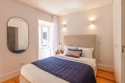 a bedroom with a large bed and a mirror at D&S -JB Apartments in Porto
