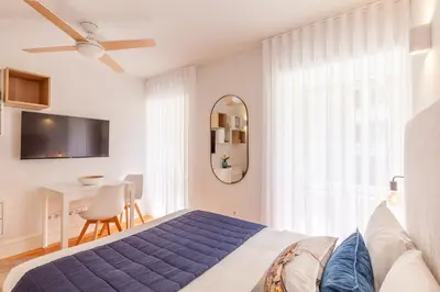 a bedroom with a blue bed and a mirror at D&S -JB Apartments in Porto