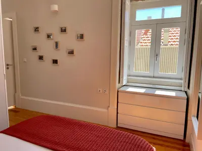 a room with a window and a red rug and a bed at Santo António Elegant Flat in Porto