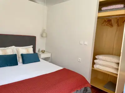 a bedroom with a bed and a closet with towels at Santo António Elegant Flat in Porto