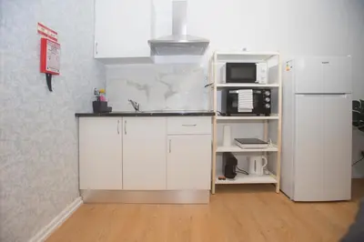 a kitchen with white cabinets and a microwave and a refrigerator at Bonsai Apartment III in Porto