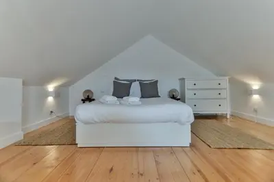 a white bedroom with a white bed and a dresser at Loft Martires da Liberdade by Porto City Hosts in Porto