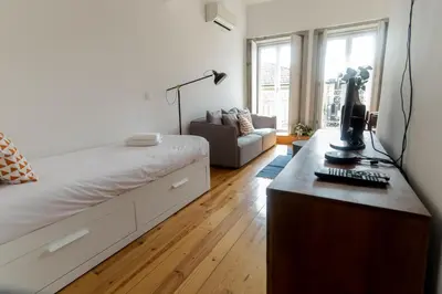 a bedroom with a large bed and a couch at Loft Martires da Liberdade by Porto City Hosts in Porto