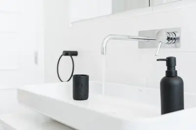 a bathroom sink with a black bottle on a counter at GuestReady - Colorful Apt near Agosto Station in Porto