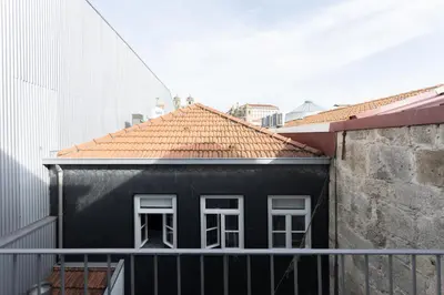 a black house with white windows and a balcony at Apartamentos da Capela in Porto