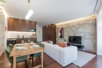 a living room with a white couch and a table at Wonderful 2BR Duplex Near River by LovelyStay in Porto