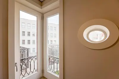 a round window in a hallway with a view of a building at Palácio das Cardosas Studio by LovelyStay in Porto