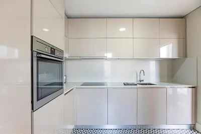 a kitchen with white cabinets and a sink at Palácio das Cardosas Studio by LovelyStay in Porto