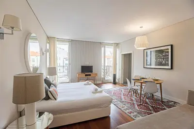 a hotel room with a bed and a dining room at Palácio das Cardosas Studio by LovelyStay in Porto