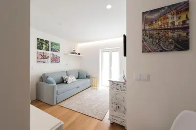 a living room with a couch and a painting on the wall at 31 de Janeiro Oporto House in Porto