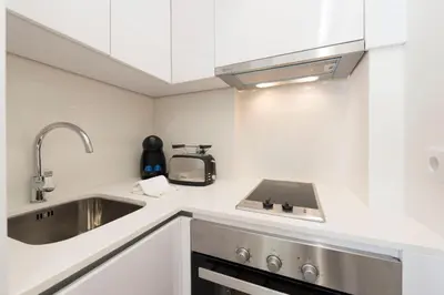 a small kitchen with a sink and a microwave at 31 de Janeiro Oporto House in Porto