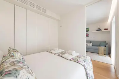 a white bedroom with a bed and a couch at 31 de Janeiro Oporto House in Porto