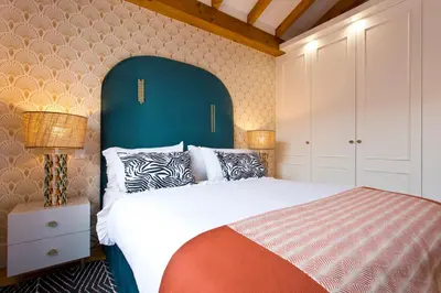 a bedroom with a large bed with a blue headboard at BOUTIQUE Rentals-THE ALMA Apt w/ balcony in Porto
