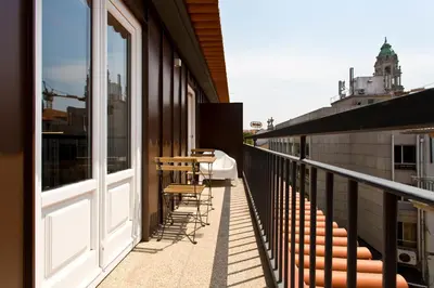 a balcony with chairs and windows on a building at BOUTIQUE Rentals-THE ALMA Apt w/ balcony in Porto