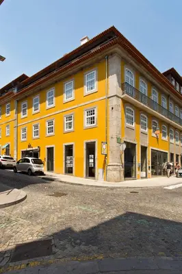 a large yellow building with cars parked in front of it at BOUTIQUE Rentals-THE ALMA Apt w/ balcony in Porto