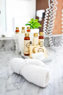 a tray with three bottles of honey and a towel at Oca Ribeira do Porto Hotel in Porto
